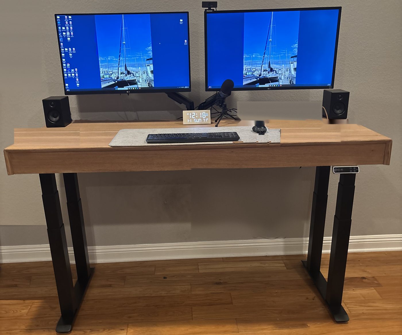 The Banded Top finished as a white oak standing desk with black adjustable legs, set up with two monitors